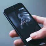 Close-up of a hand holding a smartphone with the Uber app open on the screen.